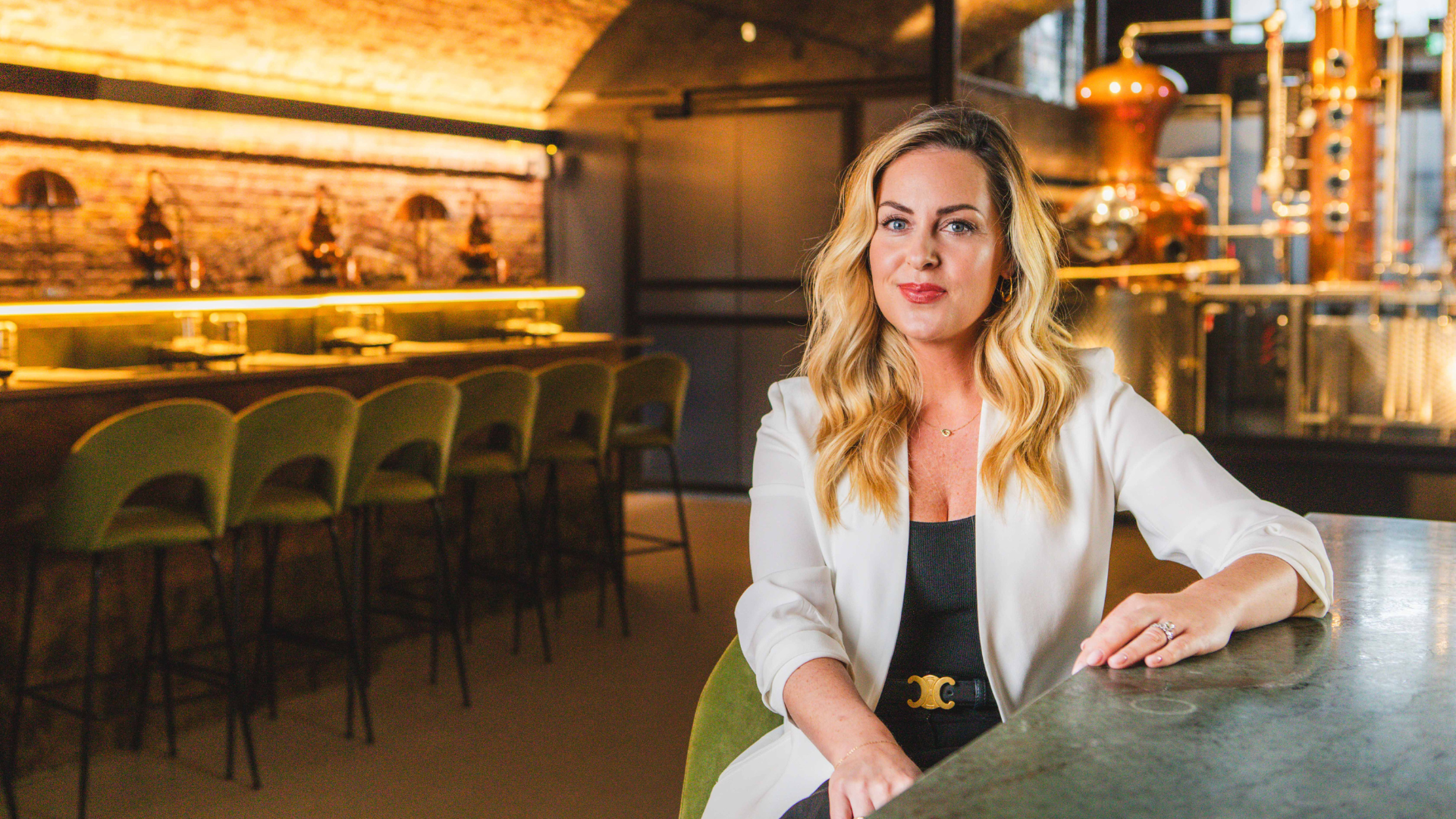 Carmen O'Neal sitting at the bar of 58 and CO Distillery